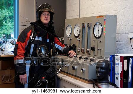 Stock Image - Firefighter in fireproof turnout gear on his regular job in the barracks.. Fotosearch