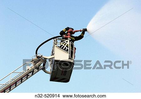 Fireman using water cannon. View Large Photo Image Picture - Fireman using water cannon.. Fotosearch