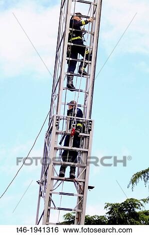 Firemen climbing up ladder View Large Photo Image Stock Photograph - Firemen climbing up ladder. Fotosearch