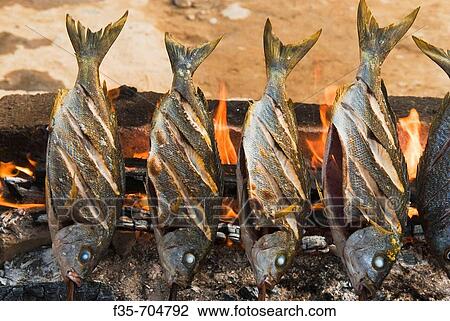 Fish grilling over fire View Large Photo Image Stock Image - Fish grilling over fire. Fotosearch