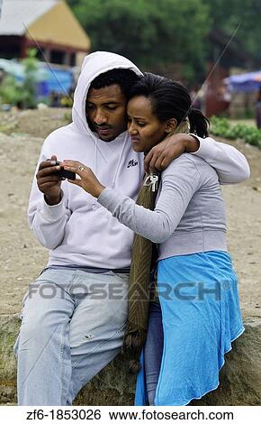 Fish Market at Lake Awassa in Awassa Ethiopia Africa with young local couple hugging while texting on cell phone 31 View Large Photo Image Stock Photograph - Fish Market at Lake Awassa in Awassa Ethiopia Africa with young local couple hugging while texting on cell phone 31. Fotosearch