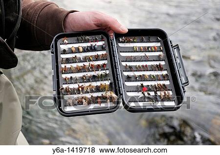 Fisherman holding fly-fishing box View Large Photo Image Stock Photo - Fisherman holding fly-fishing box. Fotosearch