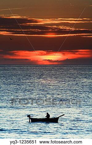 Fisherman in his boat at sunrise. Castro Urdiales, Cantabria, Spain. View Large Photo Image Stock Image - Fisherman in his boat at sunrise. Castro Urdiales, Cantabria, Spain.. Fotosearch