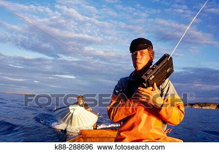 Stock Photograph - Fisherman listening to the weather forecast. Havstenssund. Bohusln. West coast of Sweden. Fotosearch