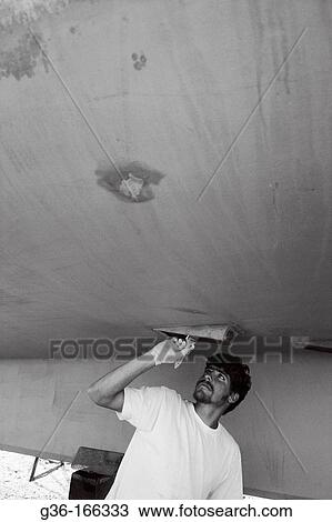 Fisherman painting boat hull View Large Photo Image Stock Image - Fisherman painting boat hull. Fotosearch