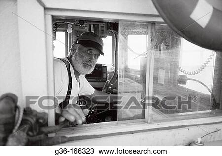 Fisherman piloting boat View Large Photo Image Stock Image - Fisherman piloting boat. Fotosearch