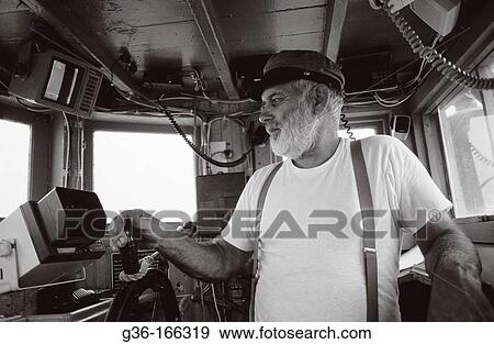 Fisherman piloting boat View Large Photo Image Stock Photo - Fisherman piloting boat. Fotosearch