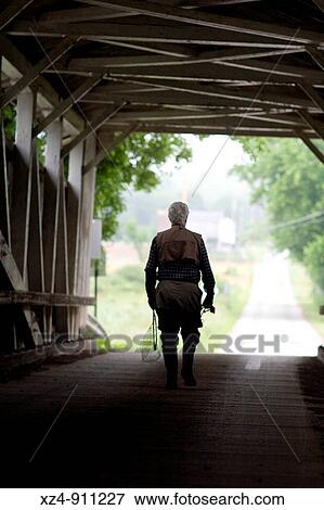fisherman walking across covered bridge in hip waders View Large Photo Image Stock Photo - fisherman walking across covered bridge in hip waders. Fotosearch