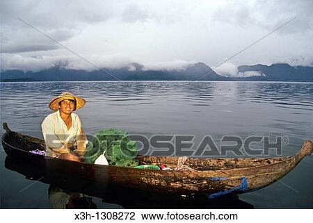 Stock Image - fisherman with dugout on the lake Maninjau, Sumatra island, Republic of Indonesia, Southeast Asia and Oceania. Fotosearch