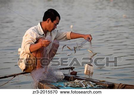 Stock Image - Fisherman work the Mekong River early in the morning outside of Phnom Penh, Cambodia.. Fotosearch