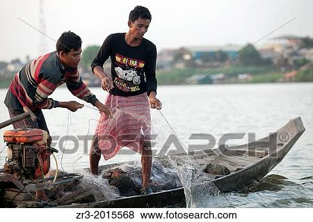 Stock Photo - Fisherman work the Mekong River early in the morning outside of Phnom Penh, Cambodia.. Fotosearch