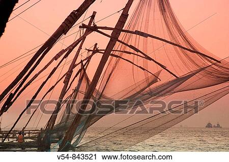 Stock Image - Fishermen and traditional fishing nets, Fort Cochin, Kerala. Fotosearch