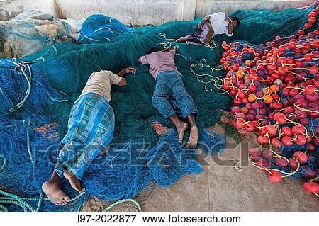 Fishermen sleep on their nets after returning from fishing in the Bay of Bengal, Tamil Nadu state, South India. View Large Photo Image Stock Photo - Fishermen sleep on their nets after returning from fishing in the Bay of Bengal, Tamil Nadu state, South India.. Fotosearch