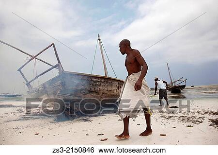 Fishermen taking care of their boat with the help of the fire at the beach, Nungwi, Zanzibar Island, Zanzibar Archipelago, Tanzania, East Africa. View Large Photo Image Stock Photograph - Fishermen taking care of their boat with the help of the fire at the beach, Nungwi, Zanzibar Island, Zanzibar Archipelago, Tanzania, East Africa.. Fotosearch