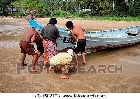 Stock Image - Fishermen with a boat, Teluk Melano, Sarawak, Borneo. Fotosearch