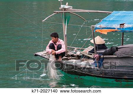 Fishing among the limestone karsts and small islands in Ha Long Bay, Vietnam, Asia. View Large Photo Image Stock Image - Fishing among the limestone karsts and small islands in Ha Long Bay, Vietnam, Asia.. Fotosearch