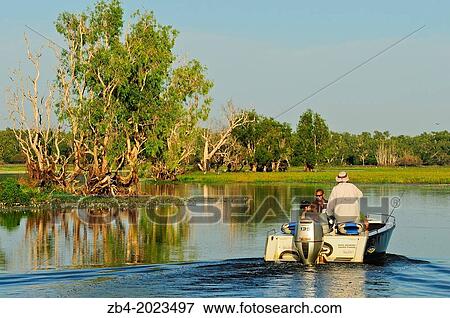Fishing boat at sunrise, Yellow Water Billabong located at the end of Jim Jim Creek, a tributary of the South Alligator River, Kakadu National Park, Northern Territory, Australia, Oceania. View Large Photo Image Stock Photo - Fishing boat at sunrise, Yellow Water Billabong located at the end of Jim Jim Creek, a tributary of the South Alligator River, Kakadu National Park, Northern Territory, Australia, Oceania.. Fotosearch