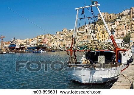 Stock Image - Fishing boats in harbor town in background Sciacca Sicily Italy Europe. Fotosearch