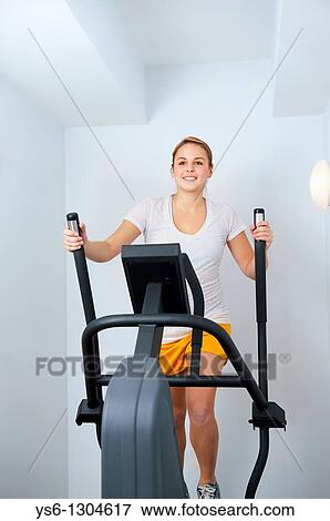 Fitness, Young Woman Working Out on Eliptical Machine View Large Photo Image Stock Photo - Fitness, Young Woman Working Out on Eliptical Machine. Fotosearch