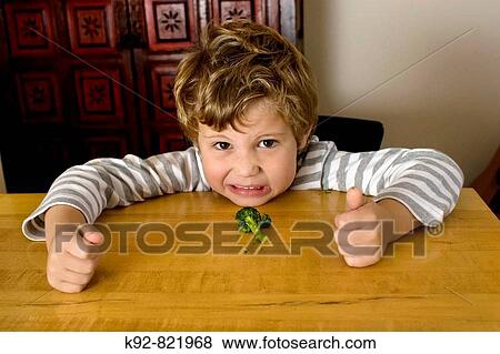 Stock Photo - Five year old boy who doesn? t want to eat broccoli.. Fotosearch