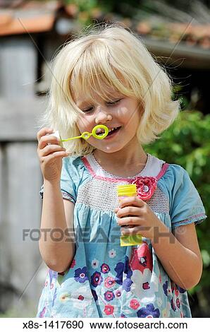 Five year old girl blowing bubbles View Large Photo Image Stock Image - Five year old girl blowing bubbles. Fotosearch