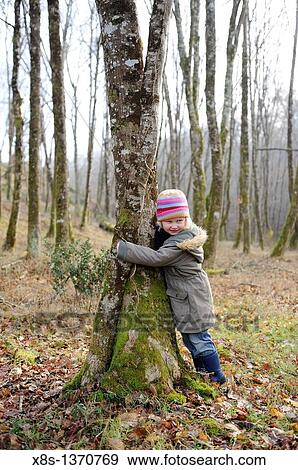 Five year old girl hugging a tree View Large Photo Image Stock Photo - Five year old girl hugging a tree. Fotosearch