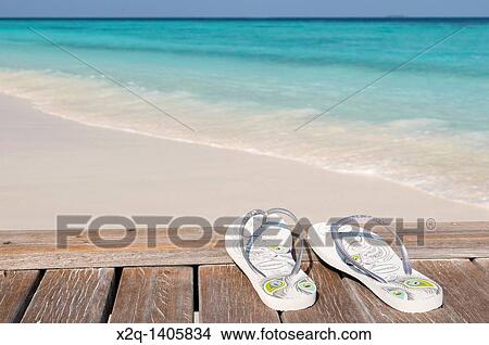 Flip flops on a jetty next to a white sand beach Maldives View Large Photo Image Picture - Flip flops on a jetty next to a white sand beach Maldives. Fotosearch