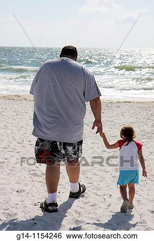 Stock Images Of Florida Bonita Springs Gulf Mexico Ocean Florida Bonita Springs Gulf Of Mexico Ocean Public Beach Little Hickory Sand Man Father Daughter Child Walking Holding Hands