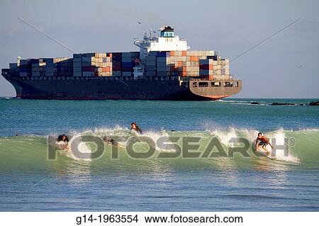 Florida, Miami Beach, Atlantic Ocean, waves, surf, surfer, surfboard, riding, man, teen, boy, cargo container ship, boat,. View Large Photo Image Picture - Florida, Miami Beach, Atlantic Ocean, waves, surf, surfer, surfboard, riding, man, teen, boy, cargo container ship, boat,.. Fotosearch