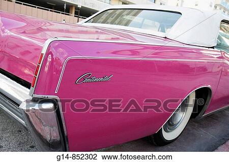 Stock Image - Florida, Miami Beach,? Ocean Drive?, classic, antique, car, auto, Lincoln, Continental, pink, magenta, convertible, white wall tire, fender, rear light,. Fotosearch