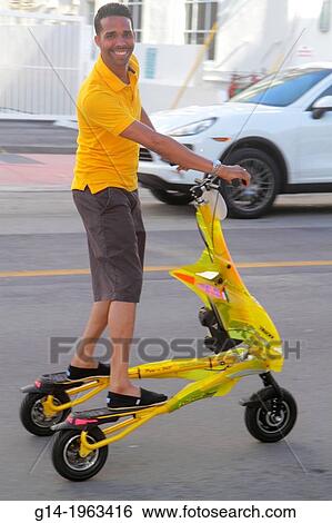 Florida, Miami Beach, Ocean Drive, Tribred by Trikke, electric vehicle, rented, rental, Hispanic, man, riding, having fun,. View Large Photo Image Stock Photograph - Florida, Miami Beach, Ocean Drive, Tribred by Trikke, electric vehicle, rented, rental, Hispanic, man, riding, having fun,.. Fotosearch