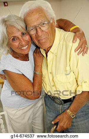 Florida, Miami Beach, Presidential Condominiums, residents, neighbors, meeting room, party, winter holidays, Christmas, senior couple, woman, female, man, male, husband, wife, hug, View Large Photo Image Stock Photo - Florida, Miami Beach, Presidential Condominiums, residents, neighbors, meeting room, party, winter holidays, Christmas, senior couple, woman, female, man, male, husband, wife, hug,. Fotosearch
