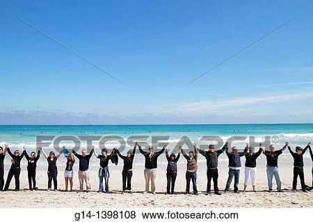 Stock Photo - Florida, Miami Beach, Surfrider Foundation, No Offshore Florida Oil Drilling Protest, black clothing represents oil, hold hands, unity, Atlantic Ocean, surf,. Fotosearch