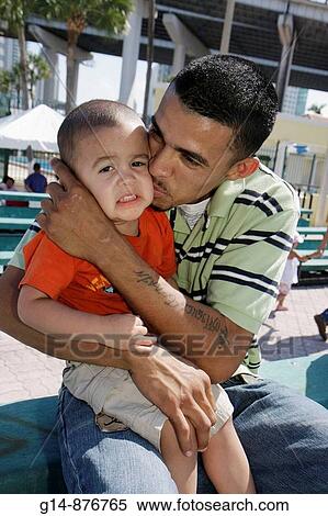 Stock Photography - Florida, Miami, Little Havana, Jose Marti Park, United Hearts Family Festival, community event, Hispanic, man, boy, toddler, child, father, son, parent, crying, console, kiss,. Fotosearch