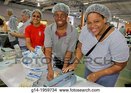 Picture - Florida, Miami, Miami-Dade County Fair And Expo, Feed My Starving Children, volunteer, community service, packing, meals, Asian, Black, woman, hairnet,.. Fotosearch