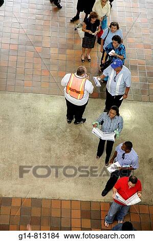 Picture - Florida, Miami, Stephen P Clark Government Center, centre, early voting, election, precinct, Black, Hispanic, man, woman, men, women, official, sample ballots, volunteer, wait, civic duty, vote, line, queue, wait,. Fotosearch