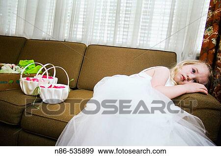 Stock Photo - Flower girl waiting on couch. Fotosearch
