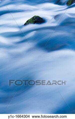 Flowing river, protruding rock View Large Photo Image Picture - Flowing river, protruding rock. Fotosearch