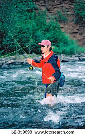 Stock Photo - Fly fisherman wading and casting. San Miguel river. Colorado. USA.. Fotosearch