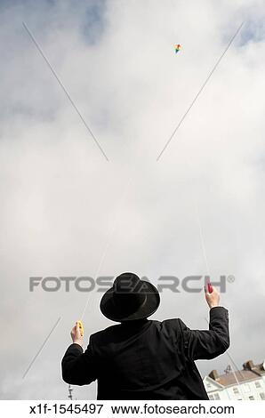 Flying a kite: Orthodox Hassidic jews on summer holiday on the beach at Aberystwyth Wales UK View Large Photo Image Stock Photo - Flying a kite: Orthodox Hassidic jews on summer holiday on the beach at Aberystwyth Wales UK. Fotosearch