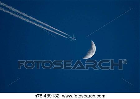 Flying plane just passing ower the moon. View Large Photo Image Stock Image - Flying plane just passing ower the moon.. Fotosearch