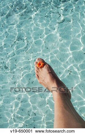 Stock Image - Foot and flower on ocean, Maldives.. Fotosearch