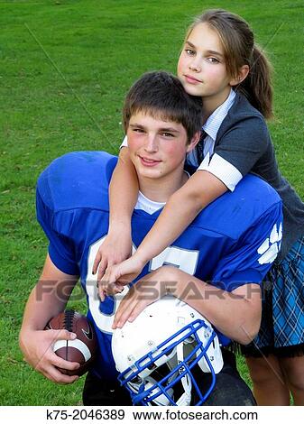 Football player getting hug from younger sister View Large Photo Image Stock Photo - Football player getting hug from younger sister. Fotosearch