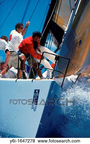 Stock Photo - Foredeck action hauling in spinnaker on racing yacht off Waikiki Honolulu Hawaii USA. Fotosearch