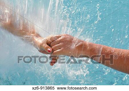 forefront of the hands of two young women under running water from a spa View Large Photo Image Stock Photography - forefront of the hands of two young women under running water from a spa. Fotosearch