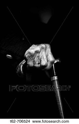 Foreground hand of an elderly woman holding a cane to walk View Large Photo Image Picture - Foreground hand of an elderly woman holding a cane to walk. Fotosearch