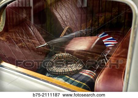 Foreground inside an antique car brand Rover with red leather upholstery with two umbrelas, hat, car blanquet and an english flag in England, UK, Europe. View Large Photo Image Stock Photo - Foreground inside an antique car brand Rover with red leather upholstery with two umbrelas, hat, car blanquet and an english flag in England, UK, Europe.. Fotosearch