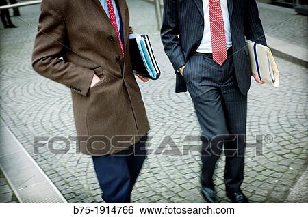 Stock Photograph - foreground of two executives walking around Bank City of London, England, UK. Fotosearch