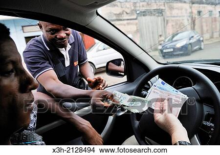 Picture - foreign exchange transaction, euros in local currency Dobra, on the black market in a street of the city of Sao Tome, Sao Tome Island, Republic of Sao Tome and Principe, Africa.. Fotosearch