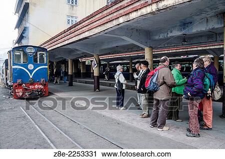 Stock Image - Foreign tourists at Darjeeling station await the departure of the toy train. At an altitude of 6812 ft, (2076. 29 m), Darjeeling is the terminating station for the toy train.. Fotosearch